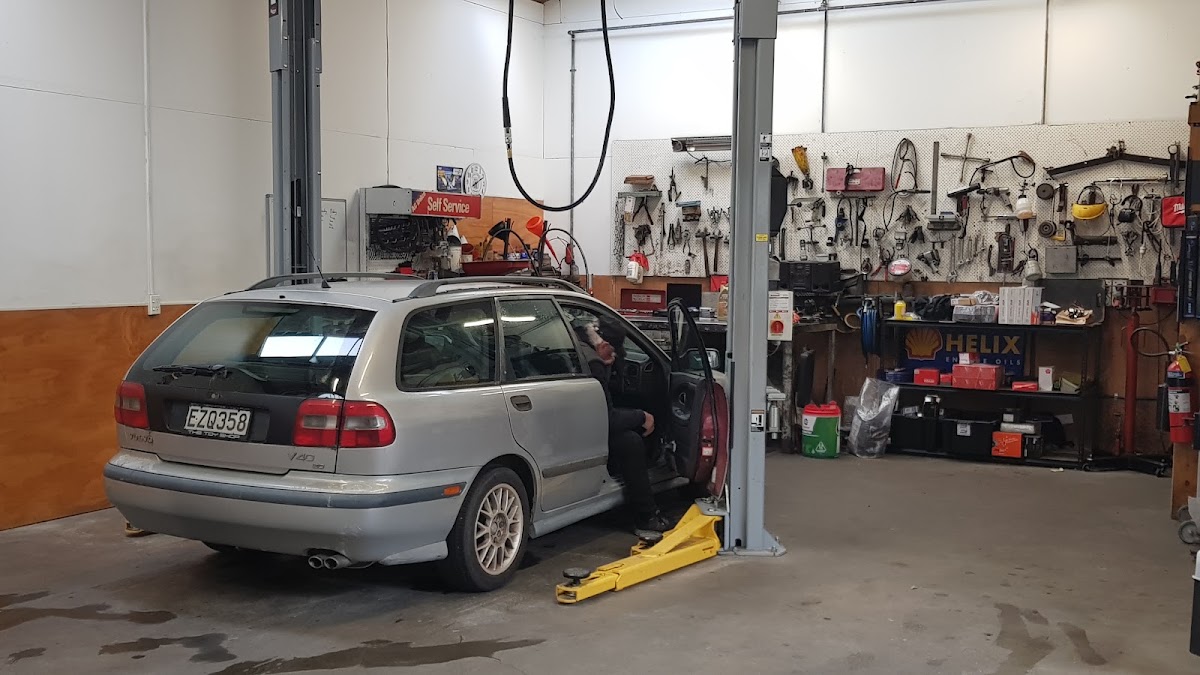 Inside the JC Autos workshop, car on the hoist and full tool wall